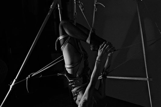 A woman hanging upside down on a pole