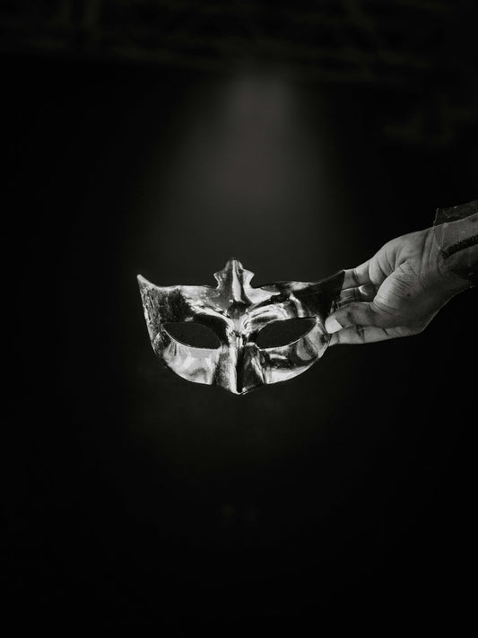 A black and white photo of a person holding a mask